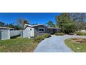 Gray house with a white fence, driveway, and landscaping at 4659 Helena Ne St, St Petersburg, FL 33703