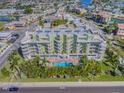 Aerial view of a condo building with a pool and lush landscaping at 11605 Gulf Blvd # 507, Treasure Island, FL 33706