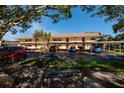 Exterior view of condo building with covered parking and a bench in the foreground at 12300 Vonn Rd # 9205, Largo, FL 33774
