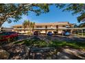 Exterior view of condo building with covered parking and a bench in the foreground at 12300 Vonn Rd # 9205, Largo, FL 33774