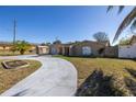 Single story home with a curved driveway and a large yard at 7430 Buchanan Dr, Port Richey, FL 34668
