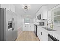Open concept kitchen with white cabinets, stainless steel appliances, and a breakfast bar at 1000 49Th N St # 214, St Petersburg, FL 33710