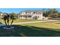 Two-story house with a large yard, driveway, and palm tree at 11305 Sweet Bay Ct, Riverview, FL 33569