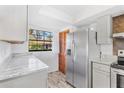 Bright kitchen features stainless steel refrigerator, granite counters, and wood look flooring at 13250 Ridge Rd # 2-1, Largo, FL 33778