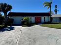 House exterior featuring a red front door and a two-car garage at 3960 Headsail Dr, New Port Richey, FL 34652