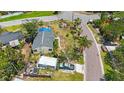 The aerial shot shows a one-story home with a gray roof, complemented by palm trees and a vintage truck nearby at 8474 Tobay N Rd, St Petersburg, FL 33702