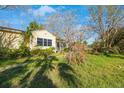 Yellow house with overgrown yard and damaged tree at 8474 Tobay N Rd, St Petersburg, FL 33702