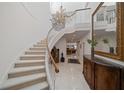 Elegant curved staircase with chandelier and ornate detailing in the foyer at 921 Osceola Rd, Belleair, FL 33756