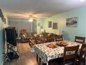 Open concept living and dining area with hardwood flooring at 9218 Mission Oaks Blvd # E, Seminole, FL 33776