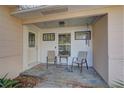 Relaxing front porch with stone tile flooring and a small table and chairs at 1008 Chester Dr, Clearwater, FL 33756