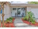 Inviting front porch with stone tile flooring and two comfy chairs at 1008 Chester Dr, Clearwater, FL 33756
