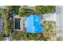 Aerial view of home with blue tarp covering roof and damaged pool at 16202 3Rd St E, Redington Beach, FL 33708