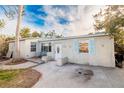 House exterior with light tan walls, light blue shutters, and small front porch at 16202 3Rd St E, Redington Beach, FL 33708