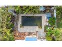 Overgrown backyard pool with surrounding debris and damaged landscaping at 16202 3Rd St E, Redington Beach, FL 33708