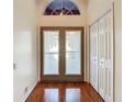 Bright entryway showcasing decorative glass doors, a transom window, and wood flooring at 3612 Covington Dr, Holiday, FL 34691