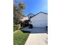 Daytime view of home's exterior with a two-car garage, walkway, and nicely landscaped front yard at 8916 Arabella Ln, Seminole, FL 33777