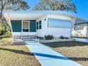Front view of a white manufactured home with light blue accents at 2331 Belleair Rd # 116, Clearwater, FL 33764