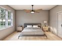 Bright and airy bedroom with wood floors, large windows, and a ceiling fan at 2713 San Luis Rd, Holiday, FL 34691