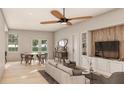 Open-concept living room and dining area with wood floors and large windows at 2713 San Luis Rd, Holiday, FL 34691