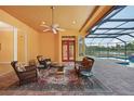 Relaxing screened-in patio with wicker furniture, overlooking the pool and lake at 3921 Mimosa Pl, Palm Harbor, FL 34685