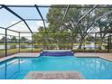 Inviting screened pool with a spa and picturesque lake views at 3921 Mimosa Pl, Palm Harbor, FL 34685