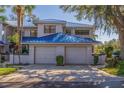 Two-car garage, blue metal roof, and paver driveway at 1688 Watermark Ne Cir, St Petersburg, FL 33702