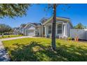 Gray house on a tree-lined street with a well-manicured lawn at 35131 Deerfield Oaks Dr, Zephyrhills, FL 33541