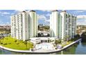 Beautiful condominium complex featuring a pool, manicured lawn, and waterfront views at 400 64Th Ave # 908, St Pete Beach, FL 33706