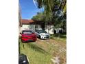 Quaint house with a grassy front yard and two parked cars at 8218 N 18Th St, Tampa, FL 33604