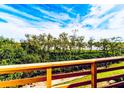 Balcony view with lush greenery and trees and a glimpse of a water view in the distance at 1710 Lighthouse S Ter # 1, South Pasadena, FL 33707