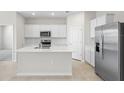Open-concept kitchen with a central island, stainless steel appliances, and ample countertop space at 2748 Winding Creek Trl, North Port, FL 34289