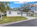 White single story home with a carport and well manicured lawn at 34124 Estates Ln, Wesley Chapel, FL 33543