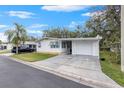 Front view of a white single story home with a carport at 34124 Estates Ln, Wesley Chapel, FL 33543