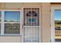 Close-up of the front door featuring decorative security bars and bright natural lighting at 4001 58Th N St # 20, Kenneth City, FL 33709