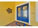 Inviting blue double front doors with decorative glass, a welcome mat, and a turtle ornament at 721 Manns Harbor Dr, Apollo Beach, FL 33572