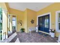 Bright yellow house with a welcoming porch, double doors, and charming decor at 721 Manns Harbor Dr, Apollo Beach, FL 33572