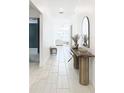 Bright entryway with tile flooring, console table, and arched mirror at 8849 Little Bluestem Dr, Land O Lakes, FL 34637