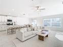 Open floor plan with white kitchen, island, and light living space at 8849 Little Bluestem Dr, Land O Lakes, FL 34637