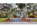 Charming two-story home with gray siding, a deck, and lush landscaping at 9034 Baywood Park Dr, Seminole, FL 33777