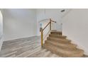 Modern staircase with wooden railing and carpeted steps at 11217 Avery Oaks Dr, Tampa, FL 33625