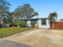 House exterior showcasing a large driveway and a nicely landscaped front yard at 133 80Th N Ave, St Petersburg, FL 33702