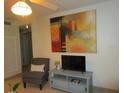 Living room featuring a large abstract painting, TV, and comfy armchair at 6000 20Th N St # 114, St Petersburg, FL 33714