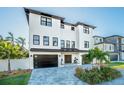Modern two-story house with white exterior, black accents, and a paver driveway at 6010 Kipps Colony E Dr, Gulfport, FL 33707