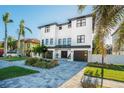 Elegant two-story home boasts a beautifully landscaped front yard and a paver driveway leading to a two-car garage at 6010 Kipps Colony E Dr, Gulfport, FL 33707