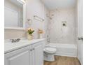 Bright bathroom featuring white vanity, marble-tiled shower-tub combo, and modern fixtures at 8609 Mallard Reserve Dr # 202, Tampa, FL 33614