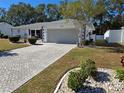 Front view of a single-story house with a paved driveway at 1707 New Bedford Dr, Sun City Center, FL 33573