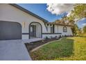 Renovated home exterior boasts a modern gray garage door and stylish landscaping at 4290 Yucatan Cir, Port Charlotte, FL 33948