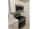 Stainless steel appliances and white cabinets in kitchen at 9744 Lake Seminole E Dr, Largo, FL 33773