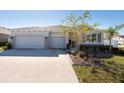 Charming single-Gathering home featuring a three-car garage, neutral paint, and manicured landscaping at 12512 Brick Cobblestone Dr, Riverview, FL 33579