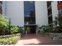 Condo building entrance with landscaping and brick pathway at 2699 Seville Blvd # 605, Clearwater, FL 33764